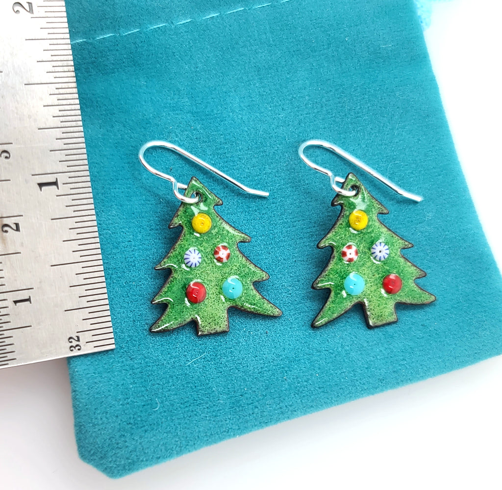 Christmas earrings by a ruler for scale