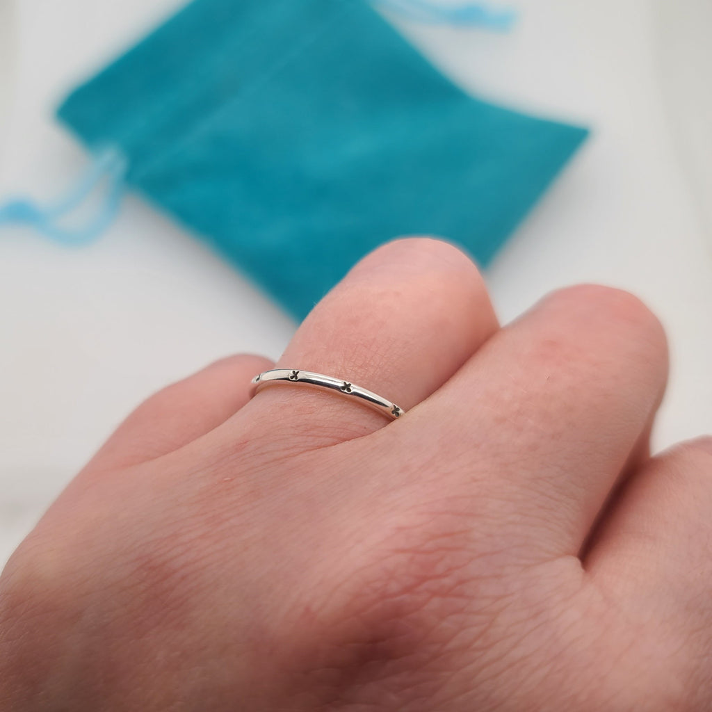 tiny X's stamped onto a narrow sterling silver ring band