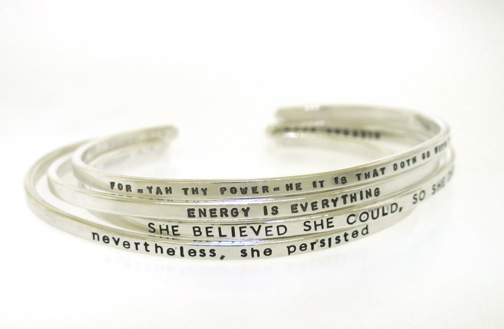 four handstamped silver cuff bracelets with inspirational messages made by kathryn riechert jewelry