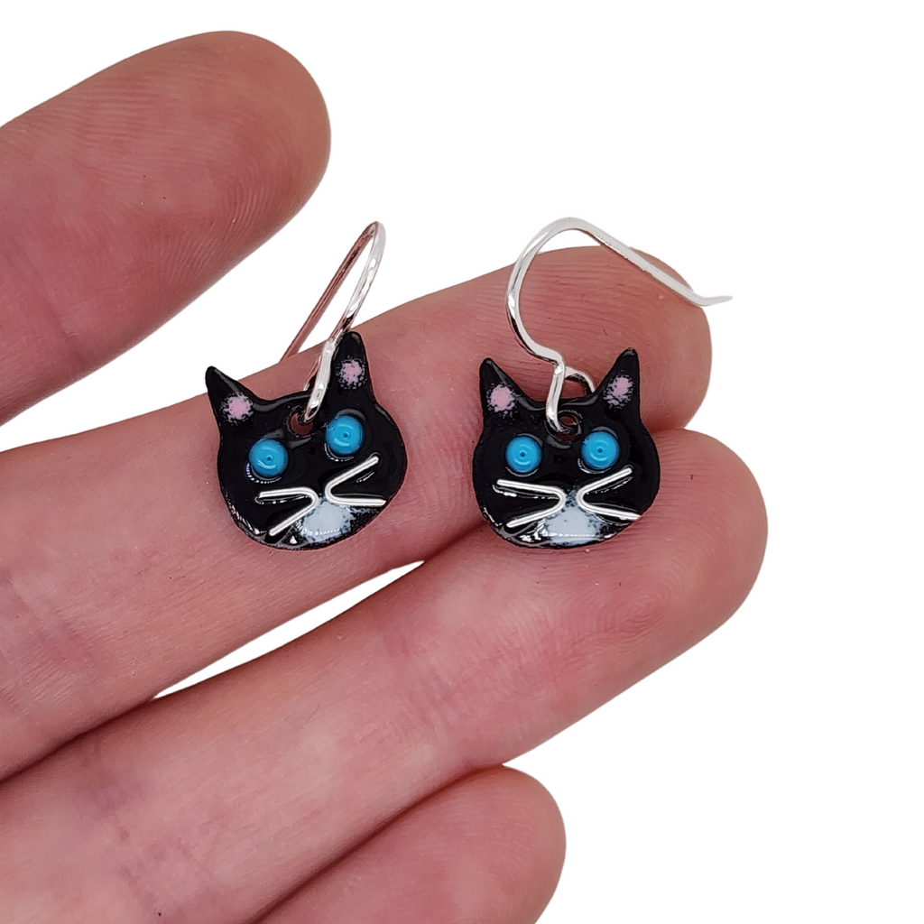 tuxie cat earrings in hand for scale