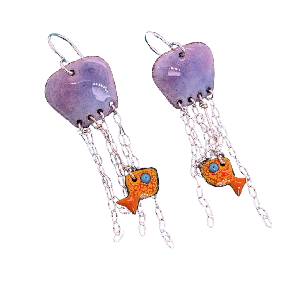 handmade jellyfish earrings made out of glass enamel fused to copper, with sterling silver chain dangling down as tentacles.  A small goldfish has been caught in the tentacles.