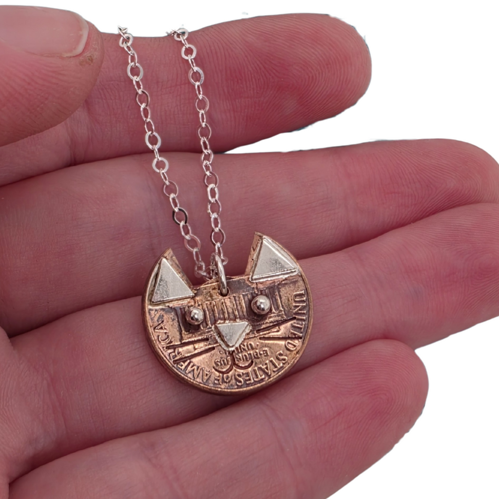 copper penny made into a small cat face charm