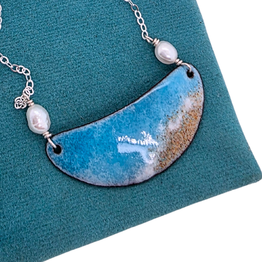 Necklace with a blue and brown pendant on a teal pouch