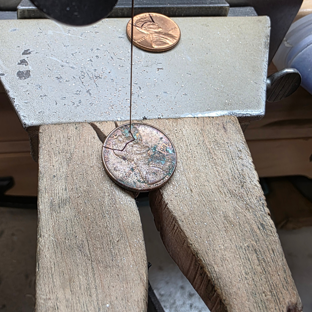 Image of a copper penny being hand sawn
