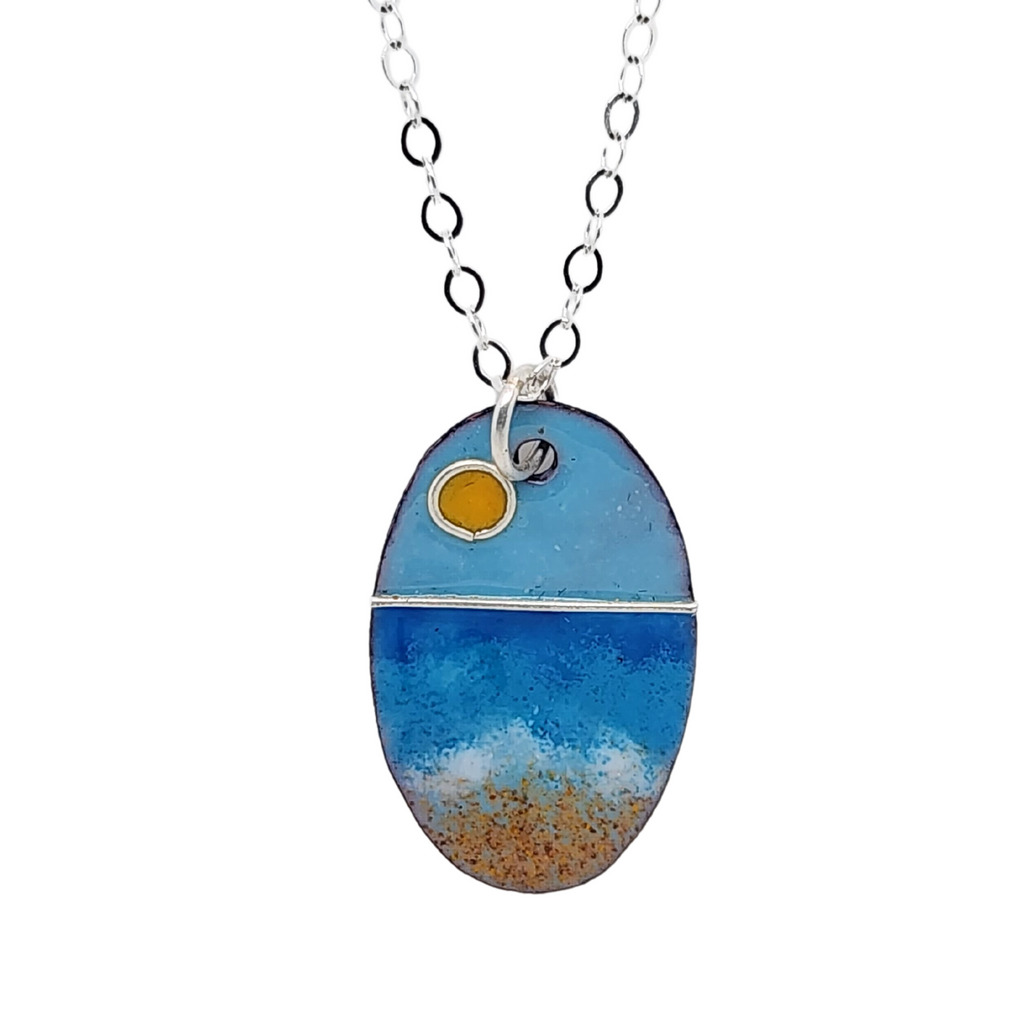 glass enamel pendant with imagery of a sunrise