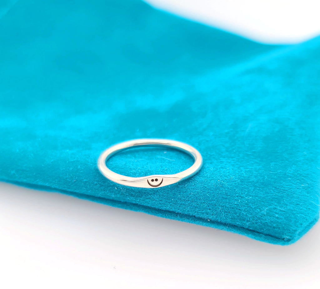 small silver ring with smile