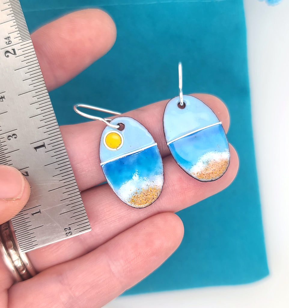 beach earrings next to a ruler for scale