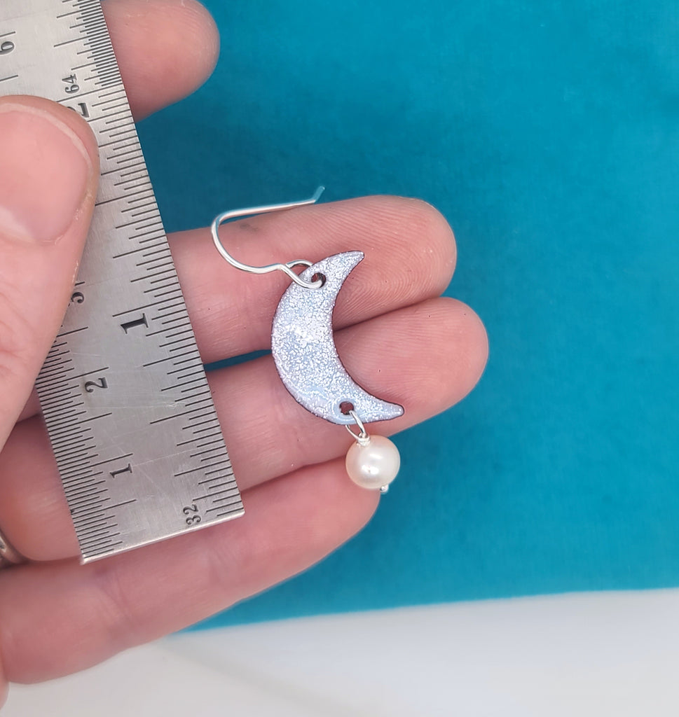handmade moon earrings by a ruler