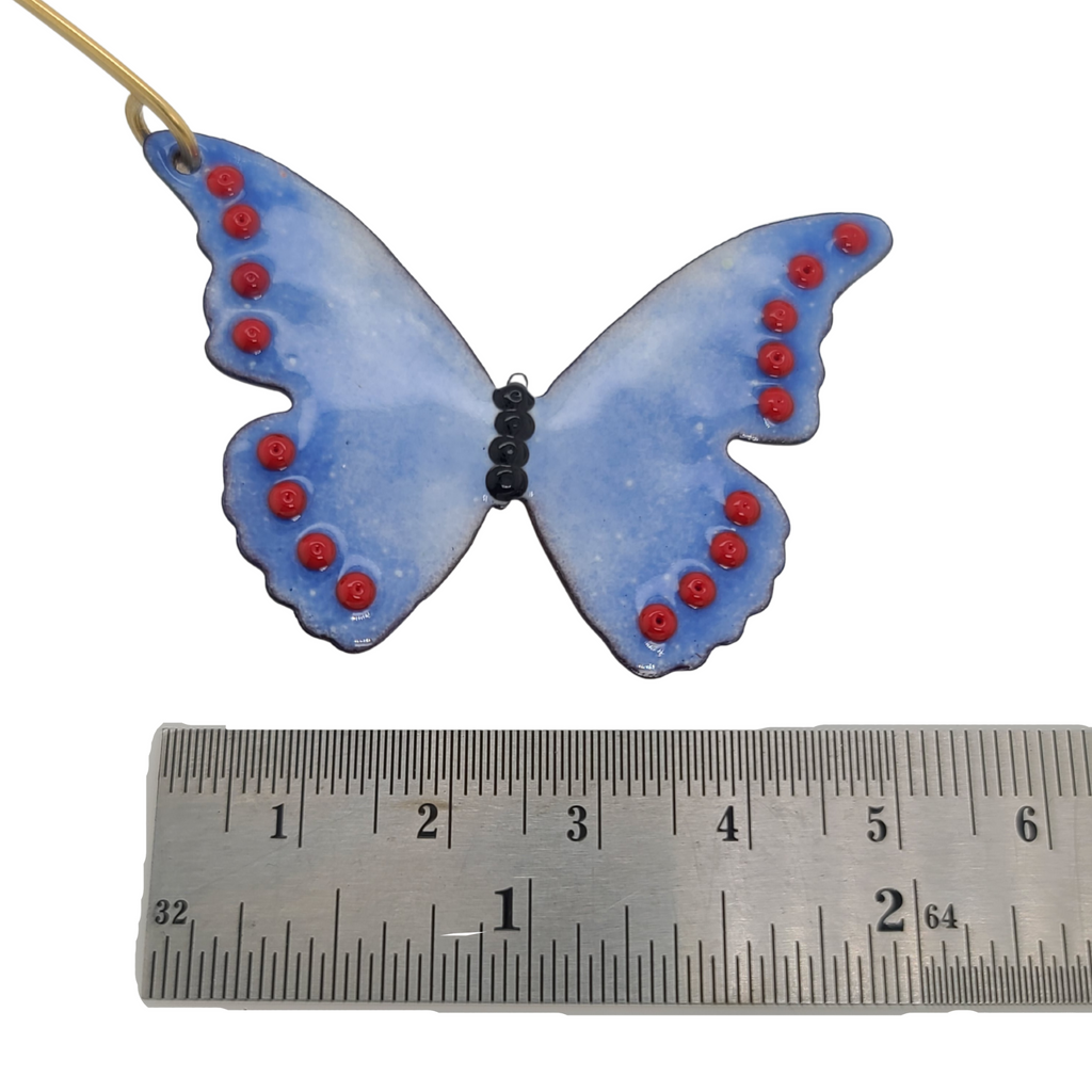 purple and red butterfly ornament next to ruler